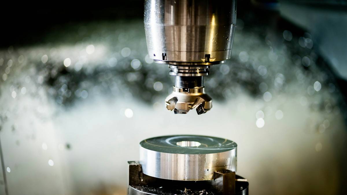 Manufacturing sourcing agent in Guangzhou checking custom part machining in a factory workshop