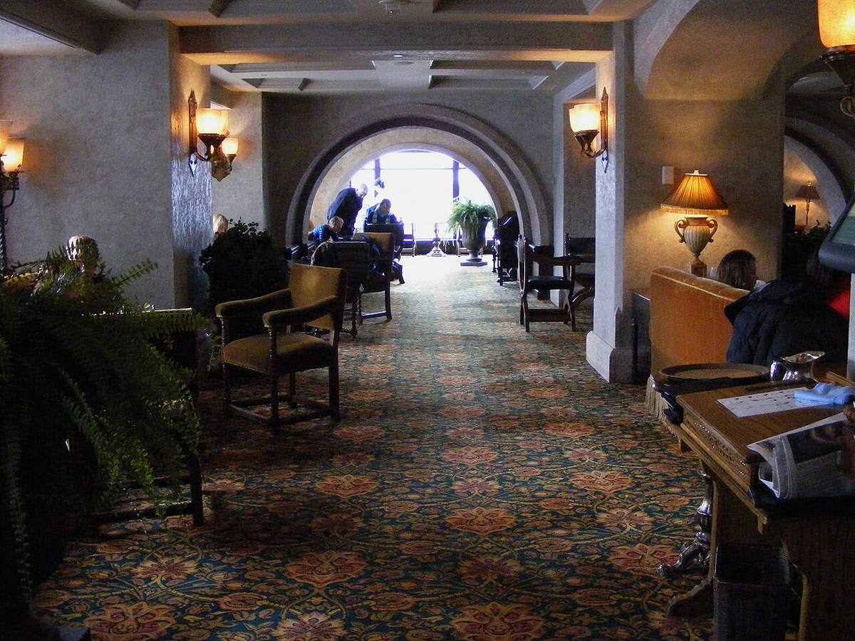 Pasillo de hotel — el eje vertical donde confluyen los sistemas de cada planta