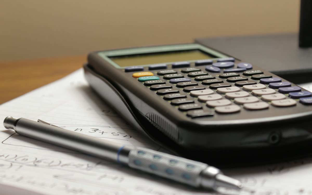 Desk calculator used to compare sourcing agent fees and hidden markups